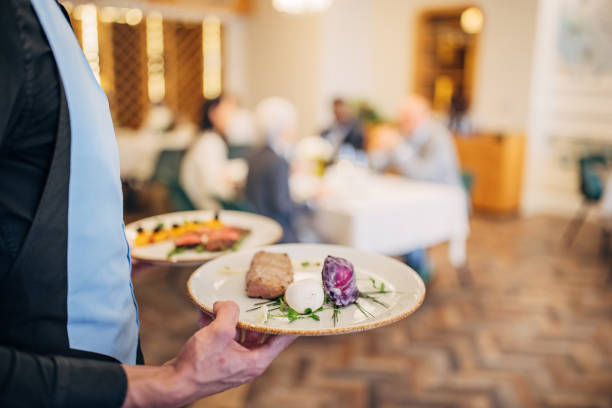 istock Waiter bringing food for guests 1441752486