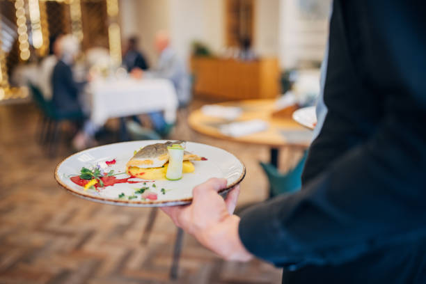 istock Waiter bringing food for guests 1441752533