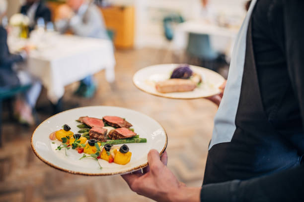 istock Waiter bringing food for guests 1441752563