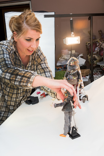 Woman Artist in Process of Making Stop Motion Animation Video by Bringing Old Puppets Back to Life