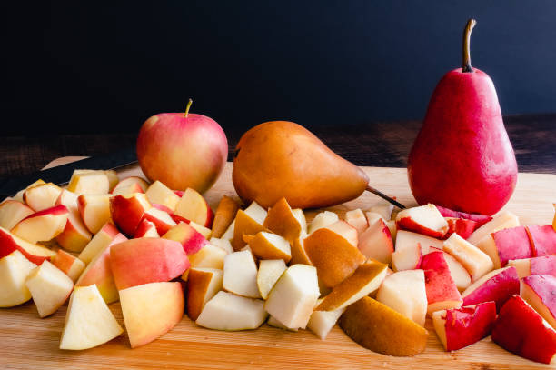 木のまな板に刻んだリンゴとナシ - russet pears ストックフォトと画像