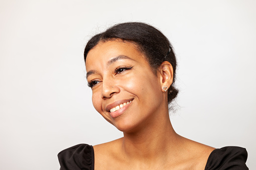Close-up studio portrait of cheerful middle aged african american woman against a white background