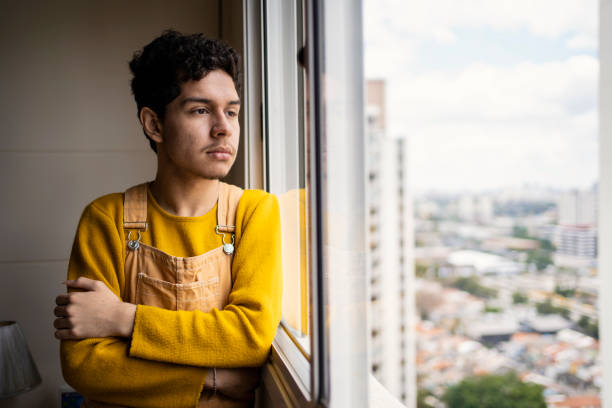 Portrait of gay young man at home with depression Portrait of gay young man at home with depression sad gay stock pictures, royalty-free photos & images