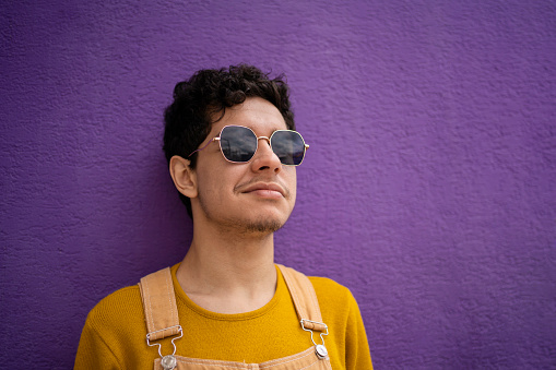 Portrait of young gay man in purple background