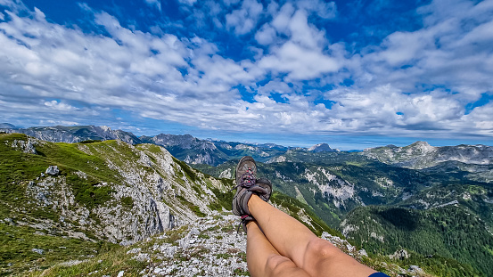 A female hiker having a break on the summit of Messnerin in Styria, Austria, Europe. The Hochschwab valley is full of lush green hills. Hiking trail, Wanderlust, Season. Sunny day. Freedom