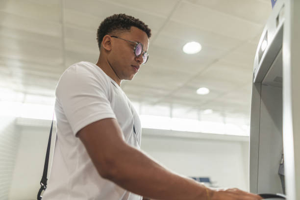 istock Young man withdrawing money at the ATM 1441761489