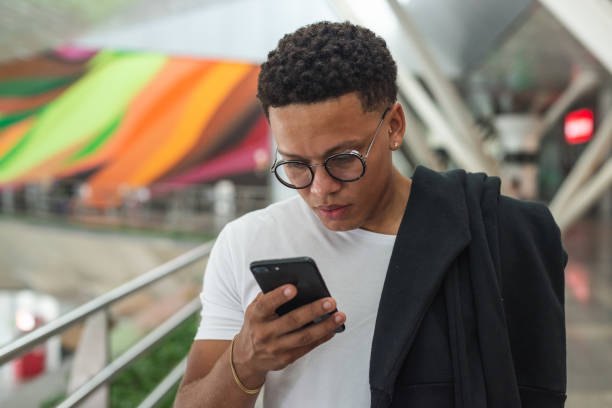 istock Young man using smartphone at the airport 1441761789