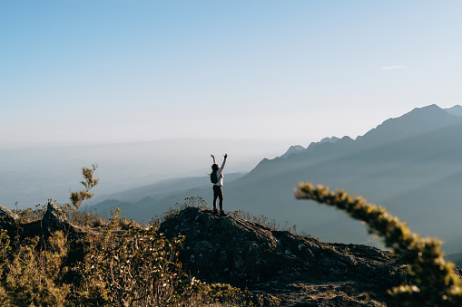 Woman celebrating on top of the mountain