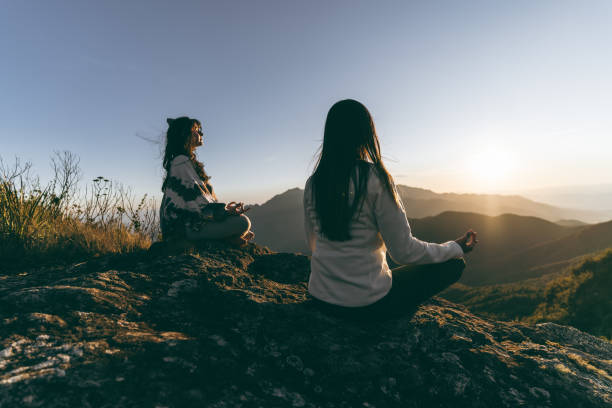 Women meditating (yoga) in the mountains