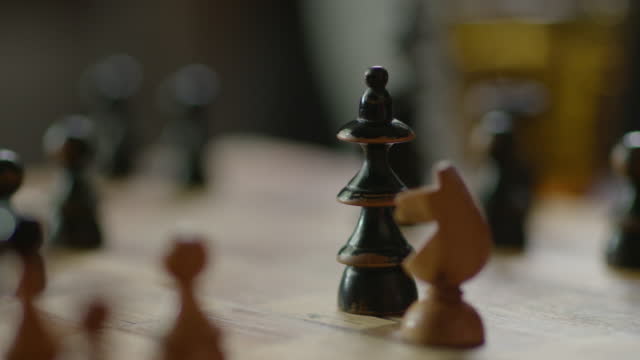 A men moves pieces on a chessboard. Extreme close up