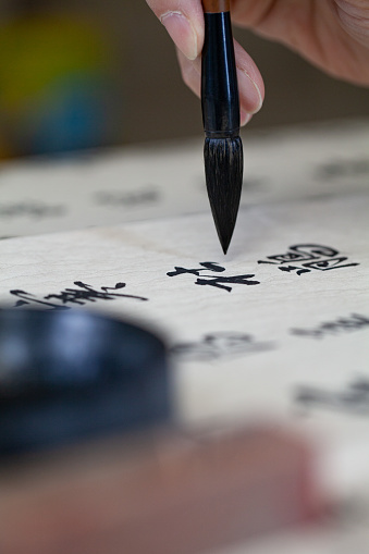 Calligraphy brush held in hand to create art of Chinese traditional writing