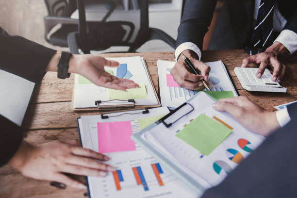 istock Financial analysts analyze business financial reports on a digital tablet planning investment project during a discussion at a meeting of corporate showing the results of their successful teamwork. 1441769898