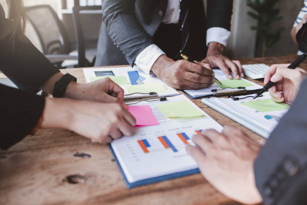 istock Financial analysts analyze business financial reports on a digital tablet planning investment project during a discussion at a meeting of corporate showing the results of their successful teamwork. 1441769933
