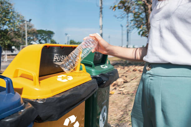 istock Woman hand throwing garbage plastic bottle into rubbish bin. Waste separation and recycling concept 1441774331