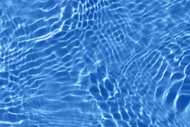 istock Defocus blurred transparent blue colored clear calm water surface texture with splashes and bubbles. Trendy abstract nature background. Water waves in sunlight with copy space. Blue watercolor shining 1441776657
