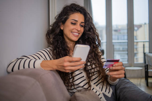 istock Cheerful  woman doing online shopping 1441779692