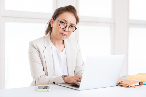 Asian senior age woman using laptop,think, business