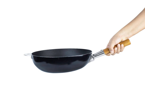 istock Hand holding cast iron pan with wooden handle isolated on white background with clipping path. 1441785620