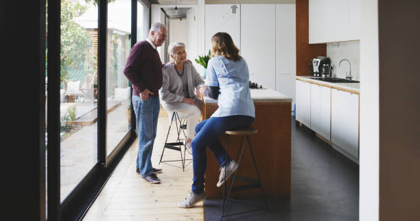 istock Senior couple, nursing home and caring nurse talking and conversation while relaxing together. Retirement, care and medical healthcare worker in communication with loving mature people 1441786175