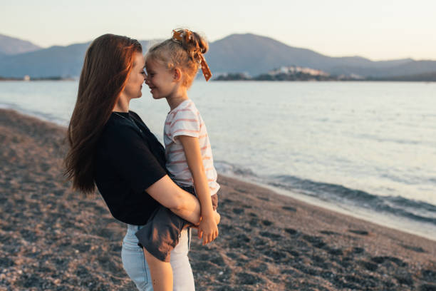 istock Mother and daughter having fun on the beach at sunset. 1441786357