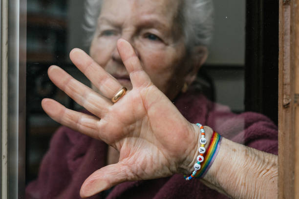 무지개 깃발과 사랑의 메시지가 있는 팔찌를 보여주는 노인 레즈비언 여성. 프라이드 데이에 게이 장로들 사이의 존중과 평등의 개념. - gay pride wristband rainbow lgbt 뉴스 사진 이미지