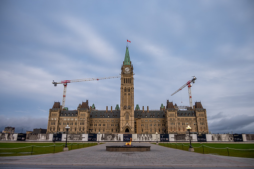 Ottawa, Ontario - October 20, 2022: Facade of the Centre Block under renovation on Canada's Parliament Hill at dawn.