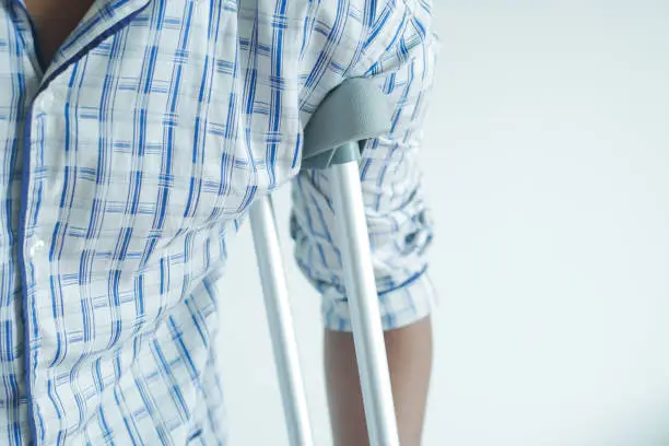Photo of young man with broken leg on crutches.
