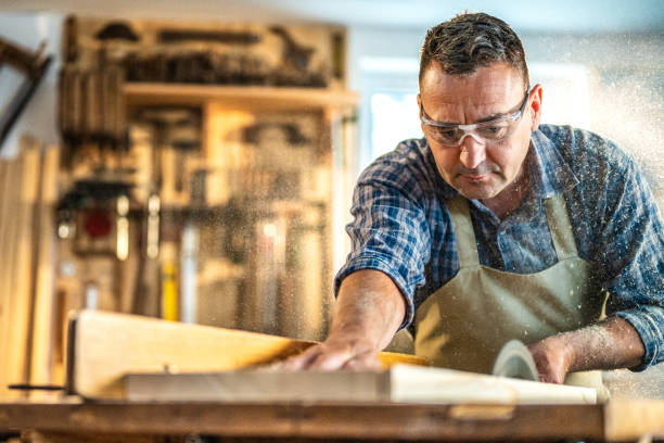 istock Professional in woodwork shop, sawing material on circular saw 1441808447