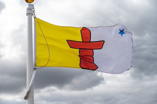 Flag of Nunavut waiving on a cloudy Canadian day.