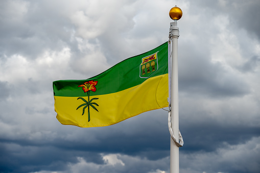 Flag of Saskatchewan waiving on a cloudy Canadian day.