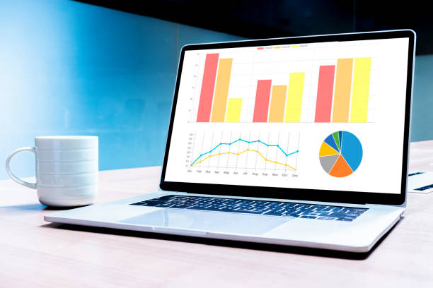 Coffee cup and laptop on table with mockup chart presentation slide show on display