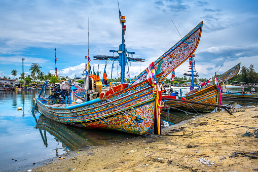 Pattani, Thailand - August 22, 2022 : Traveler thai woman pose with Kolek boat traditional fishing boat of southern provinces of Thailand with colorful art paintings.