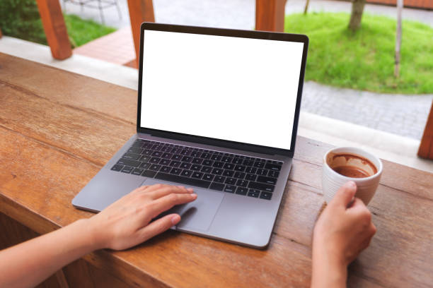 istock Mockup image of a woman using and typing on laptop computer with blank white desktop screen while drinking coffee 1441823071