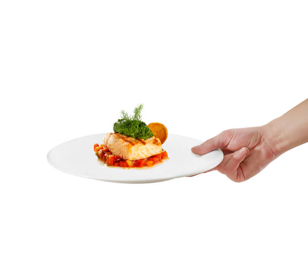Waiter serving salmon with sauce