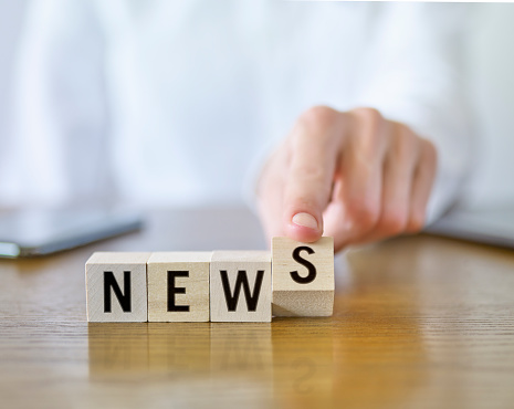 Businesswoman forming ‘News’ text with cubic blocks