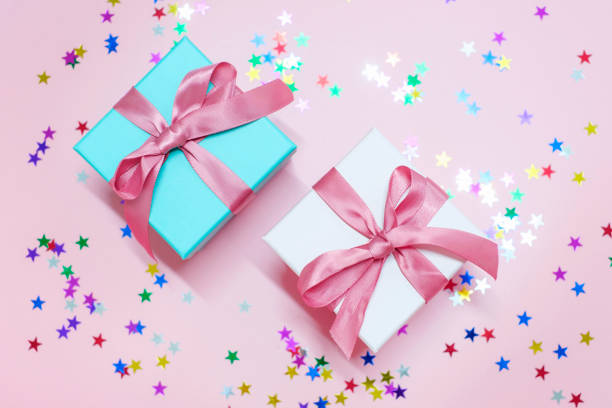 istock Two gift boxes on a background of pink confetti close-up top view. 1441825072