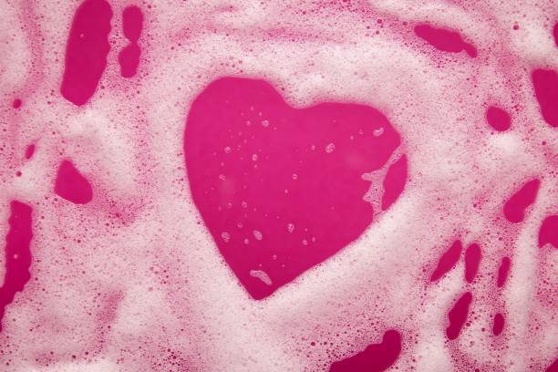 istock Heart shaped soap foam on a pink background 1441829775
