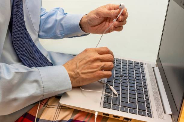 istock Man working with a laptop, using headphones and wearing a shirt, 1441830383