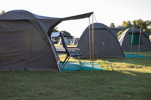 A group of grey tents set outdoor in a grassy area