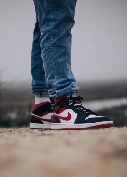 Vertical shot of a person wearing Nike Air Jordan 1 Gym Reds Vila Franca de Xira, Portugal – April 28, 2022: A vertical shot of a person wearing Nike Air Jordan 1 Gym Reds nike air photos stock pictures, royalty-free photos & images