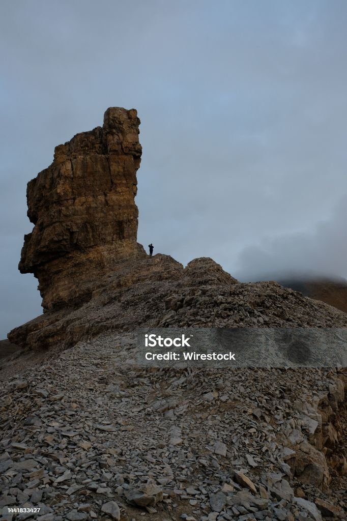 Vertical of Doigt de la Fausse Breche in the French Pyrenees with a man standing next to it A vertical of Doigt de la Fausse Breche in the French Pyrenees with a man standing next to it Adult Stock Photo