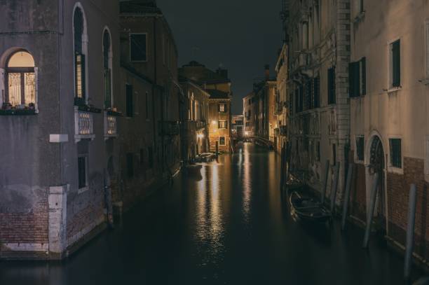istock Gondola canal with reflection surrounded by buildings in night 1441833909