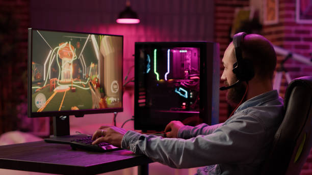 istock Static tripod shot of man using pc setup playing multiplayer online action game talking to team 1441834141