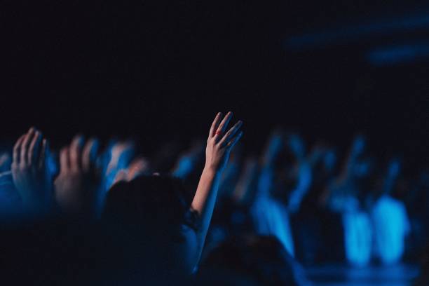istock Believers in worship gathered in a hall with blue light effect 1441834142