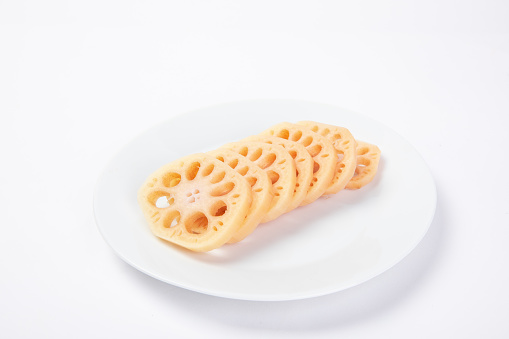 A closeup shot of lotus root slices on the plate isolated on white background