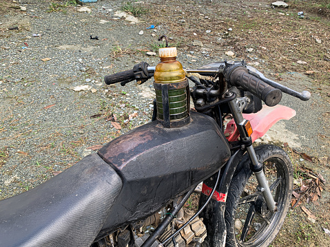 an old motorbike with a modified gas tank using an old bottle