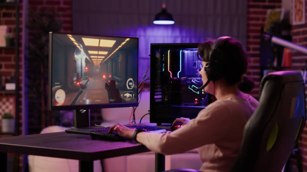 istock Gamer girl using pc setup playing multiplayer first person shooter talking on headset while explaining gameplay 1441836222