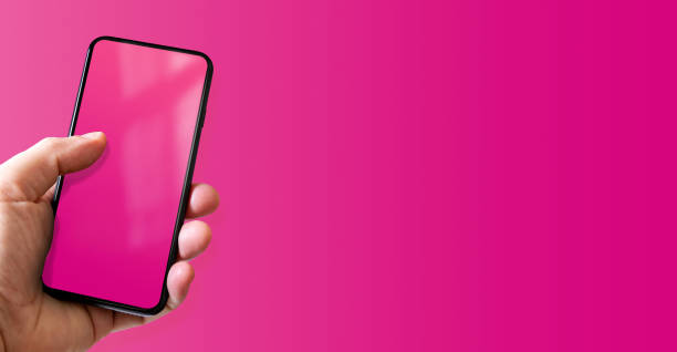 istock Hand holding a smartphone with blank pink screen. Colorful horizontal banner. 1441836226
