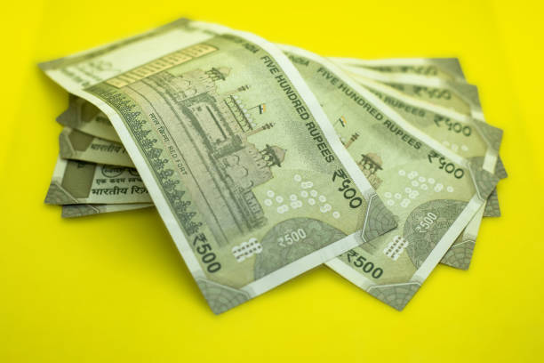 istock Closeup of Indian 500 Rupee notes on vibrant yellow background 1441836505