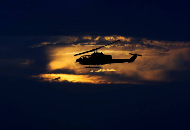 istock Army helicopter flying at sunset 1441838056